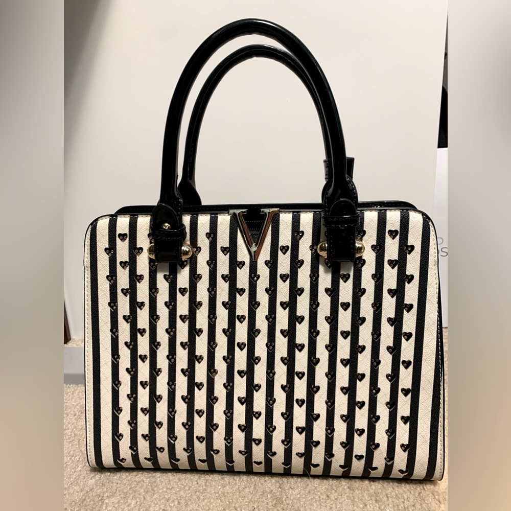 Black and white striped handbag with cutout hearts pattern